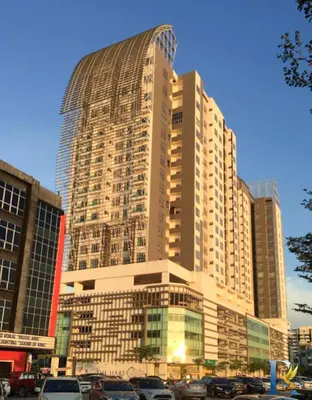 a large building with cars parked in front of it at Austin Manhattan by RR JBcity in Gua Sai