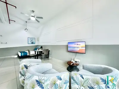 a living room with chairs and a tv on the wall at Austin Manhattan by RR JBcity in Gua Sai