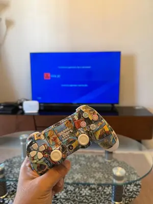 a person holding a remote control in front of a tv at AYAAN Highland Escape with PS4 gaming and Netflix at Cameron Highland in Tanah Rata