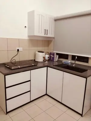 a kitchen with white cabinets and a sink at Residensi Seri Serindit Melaka in Gua Sai