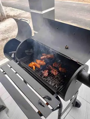 a barbecue grill with meat cooking on it at Hijrah De La Villa Parit Buntar Nibong Tebal Penang in Nibung Tebal