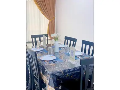a dining table with a blue table cloth and chairs at Hijrah De La Villa Parit Buntar Nibong Tebal Penang in Nibung Tebal