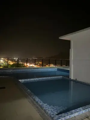 a swimming pool at night with the city lights at Mekla Hotel Studio Apartment in Gua Musang