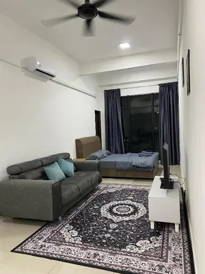 a living room with a couch and a bed at Mekla Hotel Studio Apartment in Gua Musang