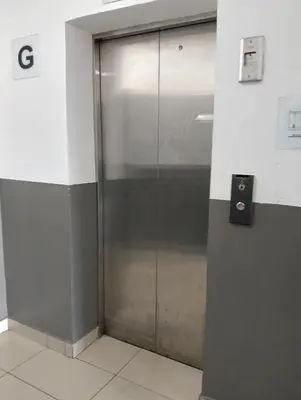 a glass elevator door in a building at Mekla Hotel Studio Apartment in Gua Musang