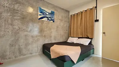 a small bedroom with a bed with a window at Batu Puteh Chalet by the River, Pool, WIFI