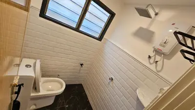 a bathroom with a toilet and a sink and a window at Batu Puteh Chalet by the River, Pool, WIFI