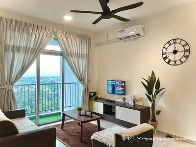 a living room with a couch and a clock on the wall at Kampung Paloh Residence Ipoh Town in Ipoh