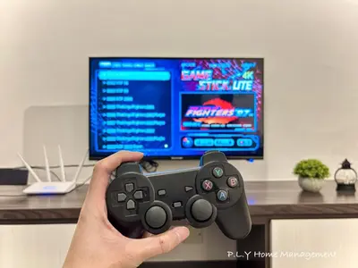 a person holding a video game controller in front of a tv at Kampung Paloh Residence Ipoh Town in Ipoh