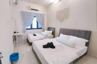 a bedroom with two beds and a couch at Ipoh Tambun Field - Landed House 9px - 3R2B in Ipoh