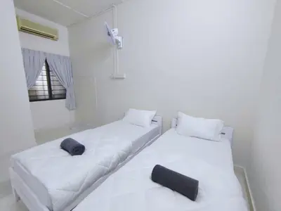 two beds in a white room with black pillows at Ipoh Tambun Field - Landed House 9px - 3R2B in Ipoh