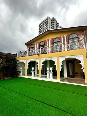 a house with a green lawn in front of it at Coconut Bay beach Villa seaview karaoke 20pax in Tanjung Bungah