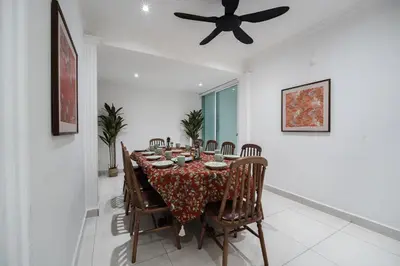 a dining room with a table with chairs and a ceiling fan at Coconut Bay beach Villa seaview karaoke 20pax in Tanjung Bungah