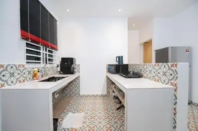 a kitchen with white counter tops and a refrigerator at Coconut Bay beach Villa seaview karaoke 20pax in Tanjung Bungah