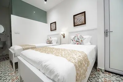 a white bedroom with two beds and a window at Coconut Bay beach Villa seaview karaoke 20pax in Tanjung Bungah