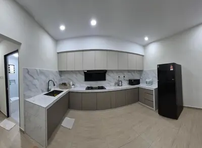 a kitchen with a black refrigerator and a sink at Hatasan Homestay Guess House