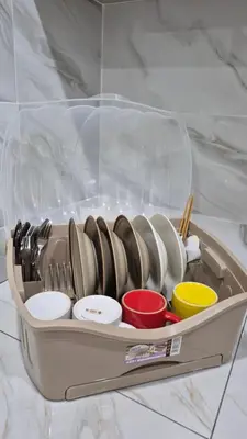 a plastic container filled with plates and bowls on a counter at Hatasan Homestay Guess House