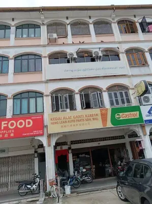 a building on a street with motorcycles parked in front at Sun Hotel Penang in George Town