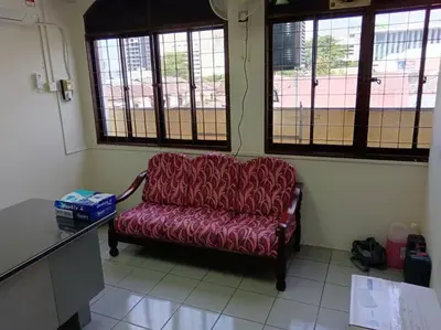 a red couch sitting in a room with windows at Sun Hotel Penang in George Town
