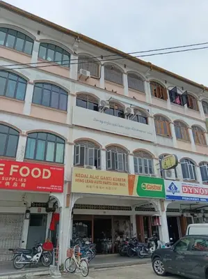 a building on a street with motorcycles parked in front at Sun Hotel Penang in George Town