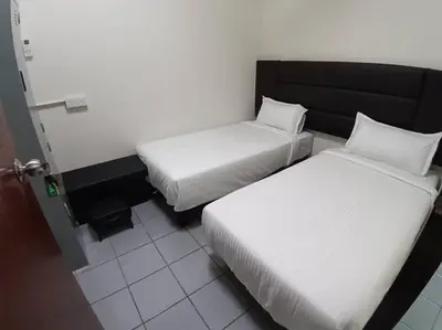 a room with two beds and a door to a room at Sun Hotel Penang in George Town