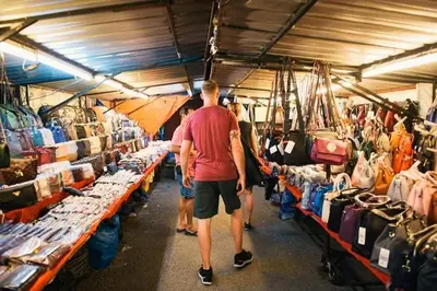 a group of people walking through a store with bags at Batu Ferringhi Sri Sayang Resort in Batu Ferringhi
