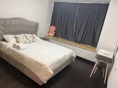 a bedroom with a bed and a window with a teddy bear at R&F Seine Region in Gua Sai