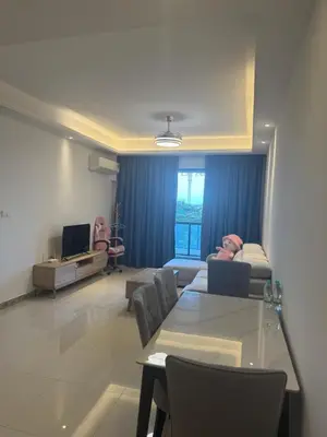 a living room with a table and chairs and a couch at R&F Seine Region in Gua Sai