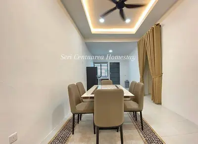a dining room with a table and chairs and a ceiling fan at Seri Centuarea Homestay, Seri Iskandar in Seri Iskandar
