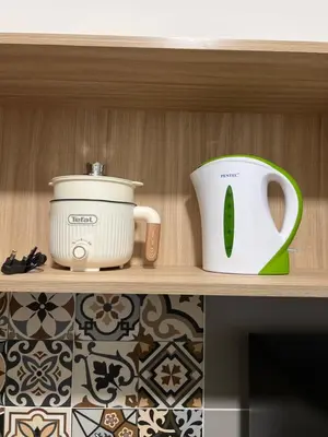 a shelf with a crock pot and a toaster at Homestay Kesidang in Seri Iskandar