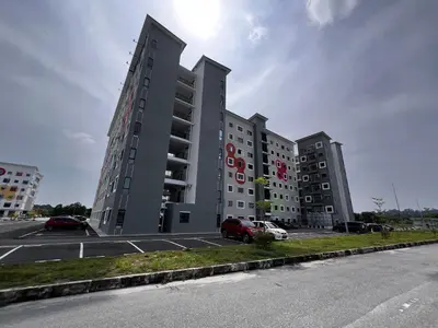 a large building with cars parked in a parking lot at Homestay Kesidang in Seri Iskandar