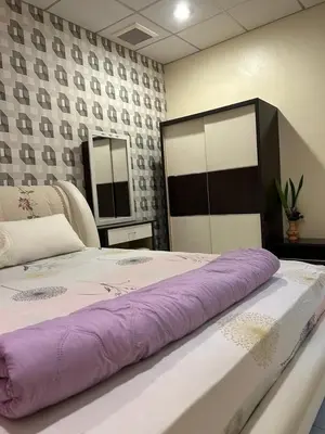 a large bed with a purple blanket on top of it at Taman Gerik Homestay in Gerik
