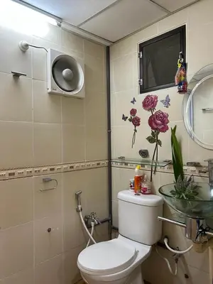 a bathroom with a toilet and a sink with flowers on the wall at Taman Gerik Homestay in Gerik