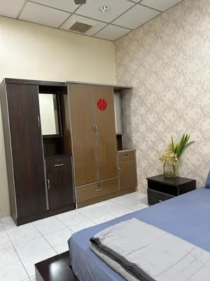 a bedroom with a bed and wooden wardrobes at Taman Gerik Homestay in Gerik