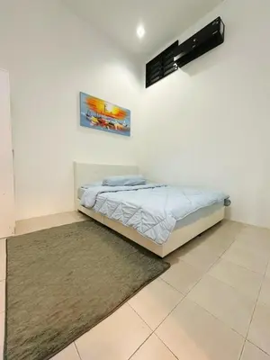 a bedroom with a bed and a painting on the wall at Ipoh Pengkalan Homestay in Ipoh