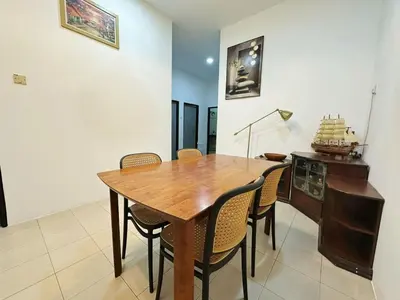 a dining room with a wooden table and chairs at Ipoh Pengkalan Homestay in Ipoh