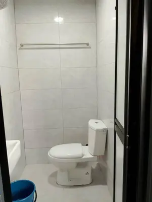 a white bathroom with a toilet and a tub at QAUSAR HOMESTAY KERLING Hulu Selangor in Kerling