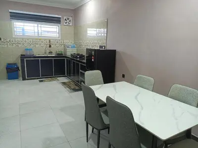 a kitchen with a table and chairs in a room at QAUSAR HOMESTAY KERLING Hulu Selangor in Kerling