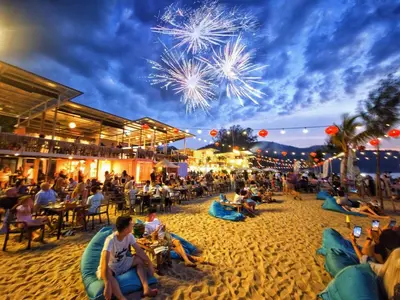 a crowd of people sitting on the beach watching fireworks at Azure Haven - Seaview Resort Home, By the Sea Batu Ferringhi in Batu Ferringhi
