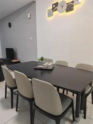 a dining room with a black table and chairs at Cozy Haven \u6696\u5fc3\u5c45 in Simpang Ampat