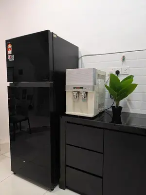 a microwave sitting on a black counter with a plant at Cozy Haven \u6696\u5fc3\u5c45 in Simpang Ampat