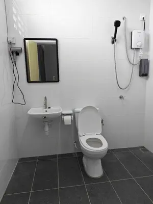 a bathroom with a toilet and a sink and a mirror at Cozy Haven \u6696\u5fc3\u5c45 in Simpang Ampat