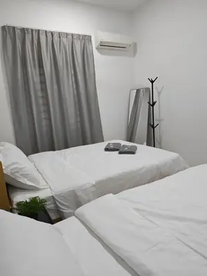 a room with two beds and a window at Cozy Haven \u6696\u5fc3\u5c45 in Simpang Ampat