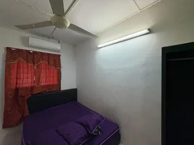 a room with a purple bed and a ceiling fan at YDK Homestay in Padang Rengas