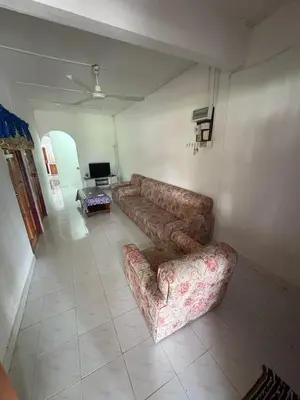a living room with a couch and a tv at YDK Homestay in Padang Rengas
