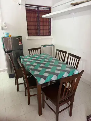 a kitchen with a table with chairs and a table cloth on it at YDK Homestay in Padang Rengas