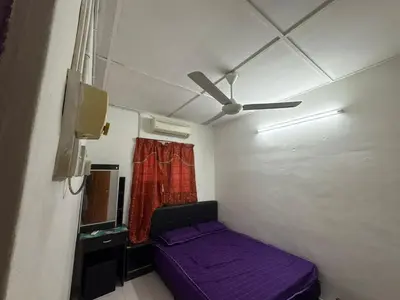a small room with a purple bed and a ceiling fan at YDK Homestay in Padang Rengas