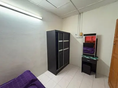 a room with a cabinet and a table in it at YDK Homestay in Padang Rengas