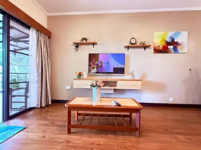 a living room with a coffee table and a tv at Equatorial Hill Resort, Mountain view In Cameron Highlands in Brinchang