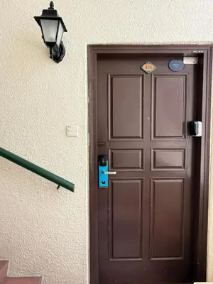 a brown door with a light next to it at Equatorial Hill Resort, Mountain view In Cameron Highlands in Brinchang
